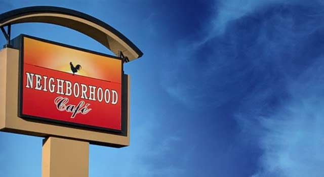 A tall sign against a blue sky displays